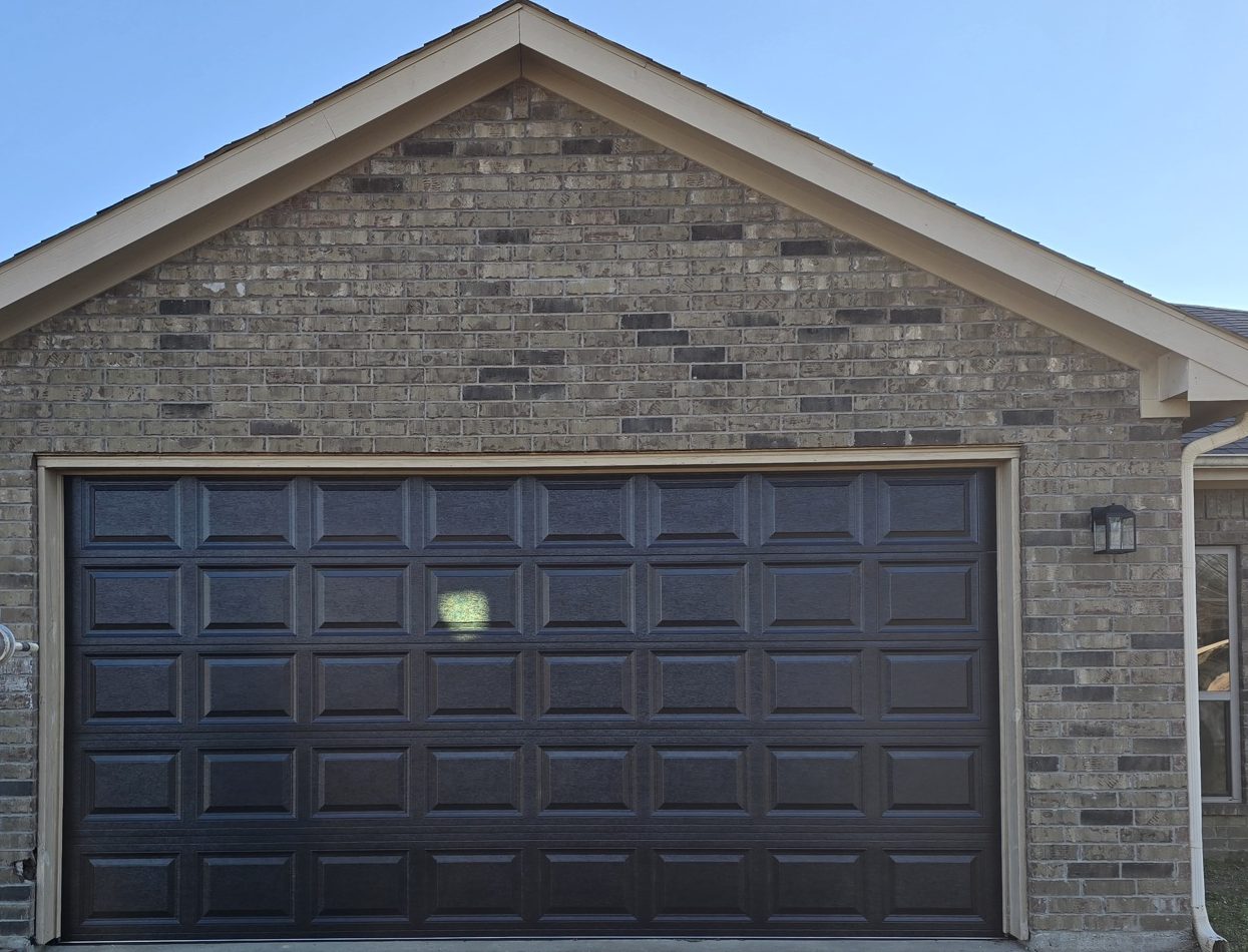 A single dark raised-panel garage door on a home